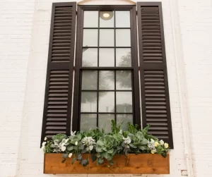 Ways To Enhance Your Front Entrance: Give Your Windows Some Love; Home window with black shutters and a flower box