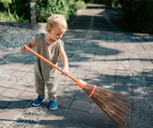 Ways To Enhance Your Front Entrance: Keep It Clean; A young kid sweeping outside