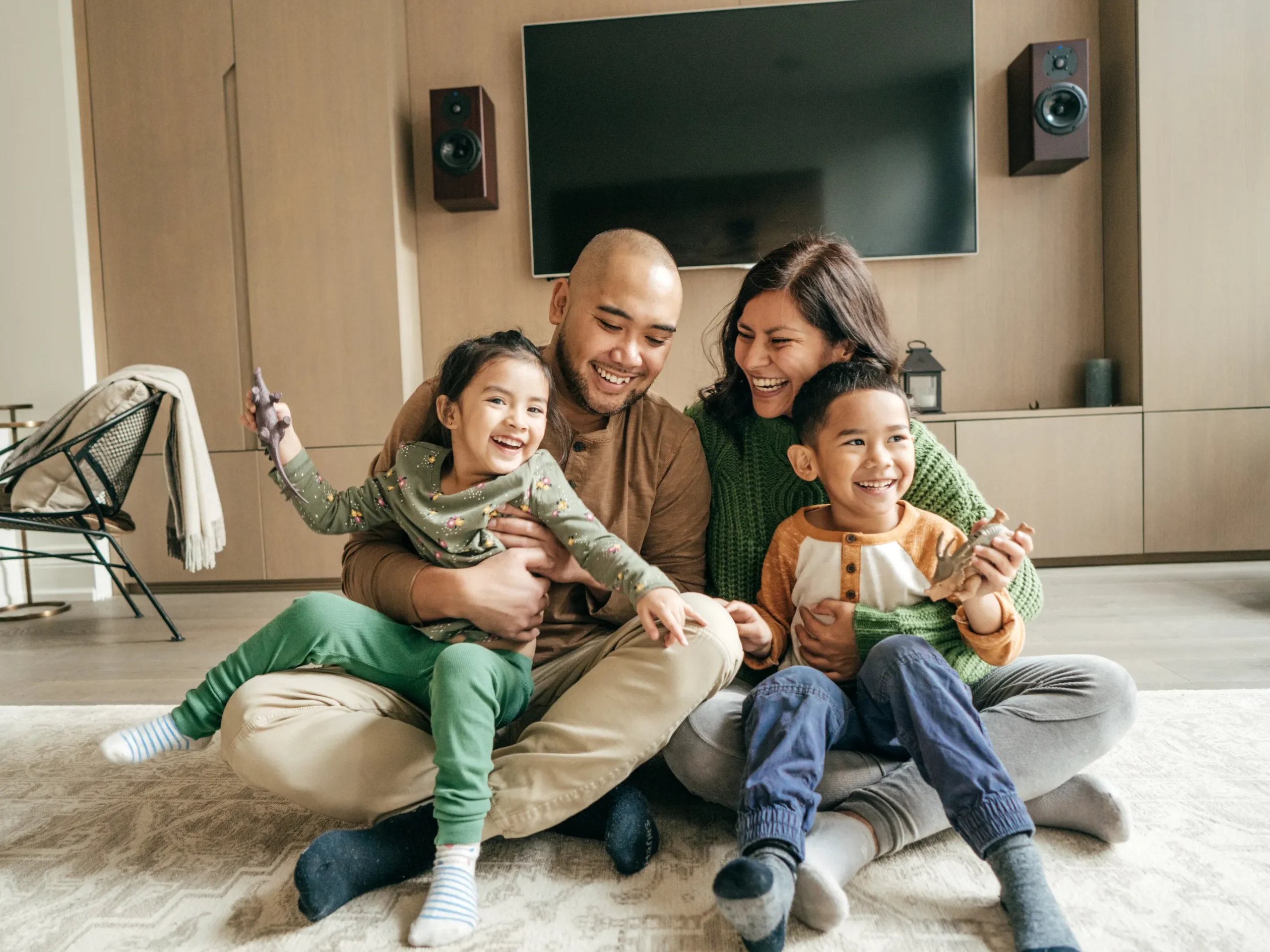 family sitting on living room floor laughing