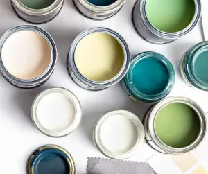 collection of open paint cans on ground - yellow, blue, green, white, etc