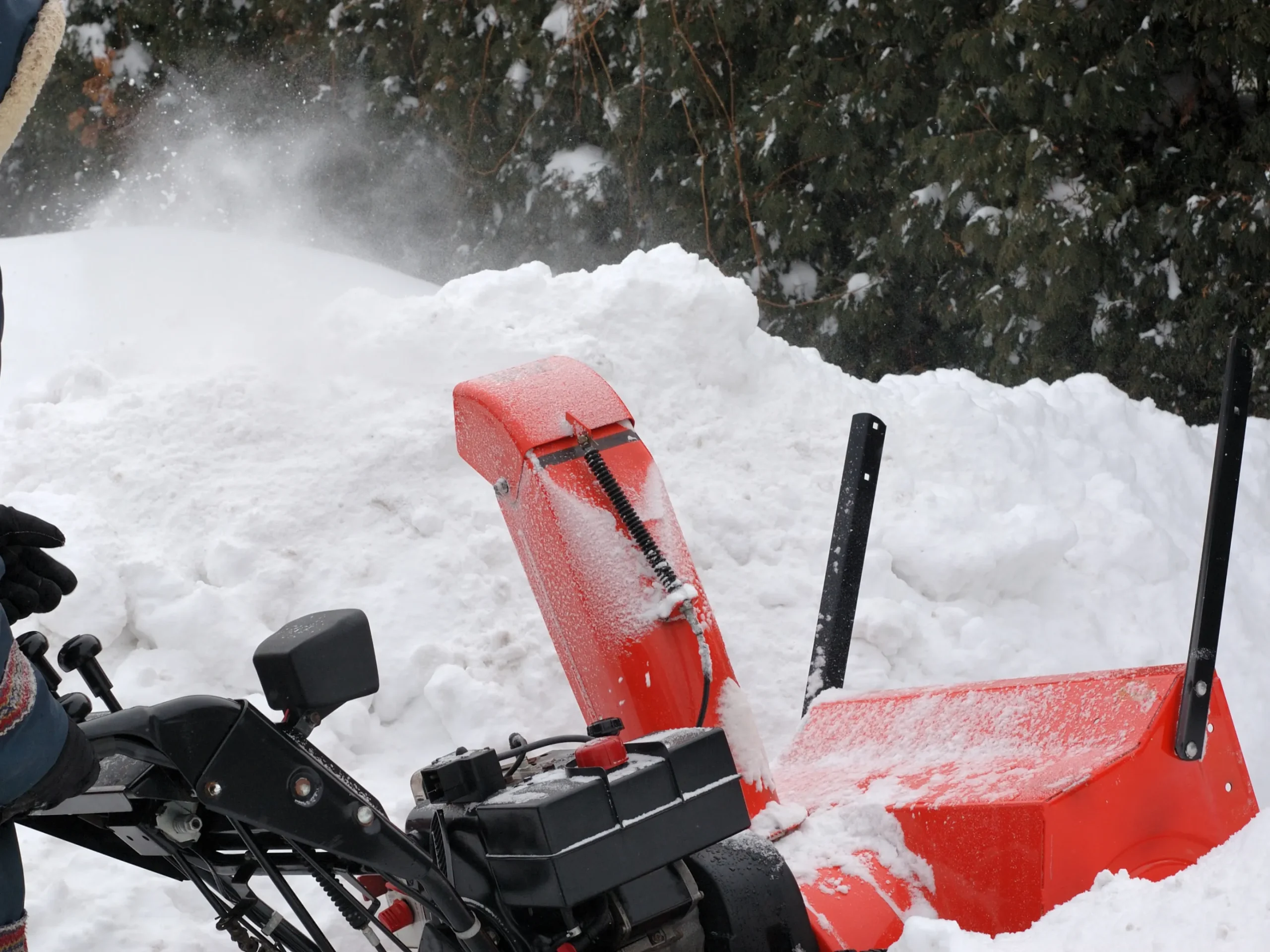 red snow blower plowing snow