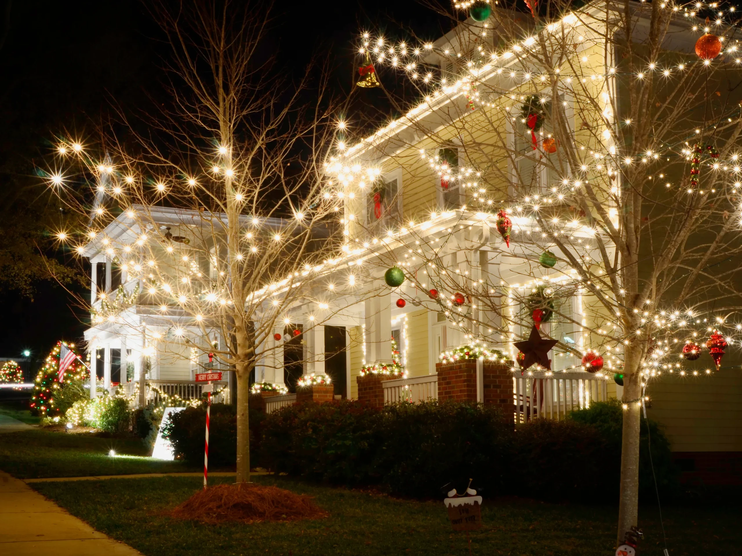 Christmas lights hung on house and trees