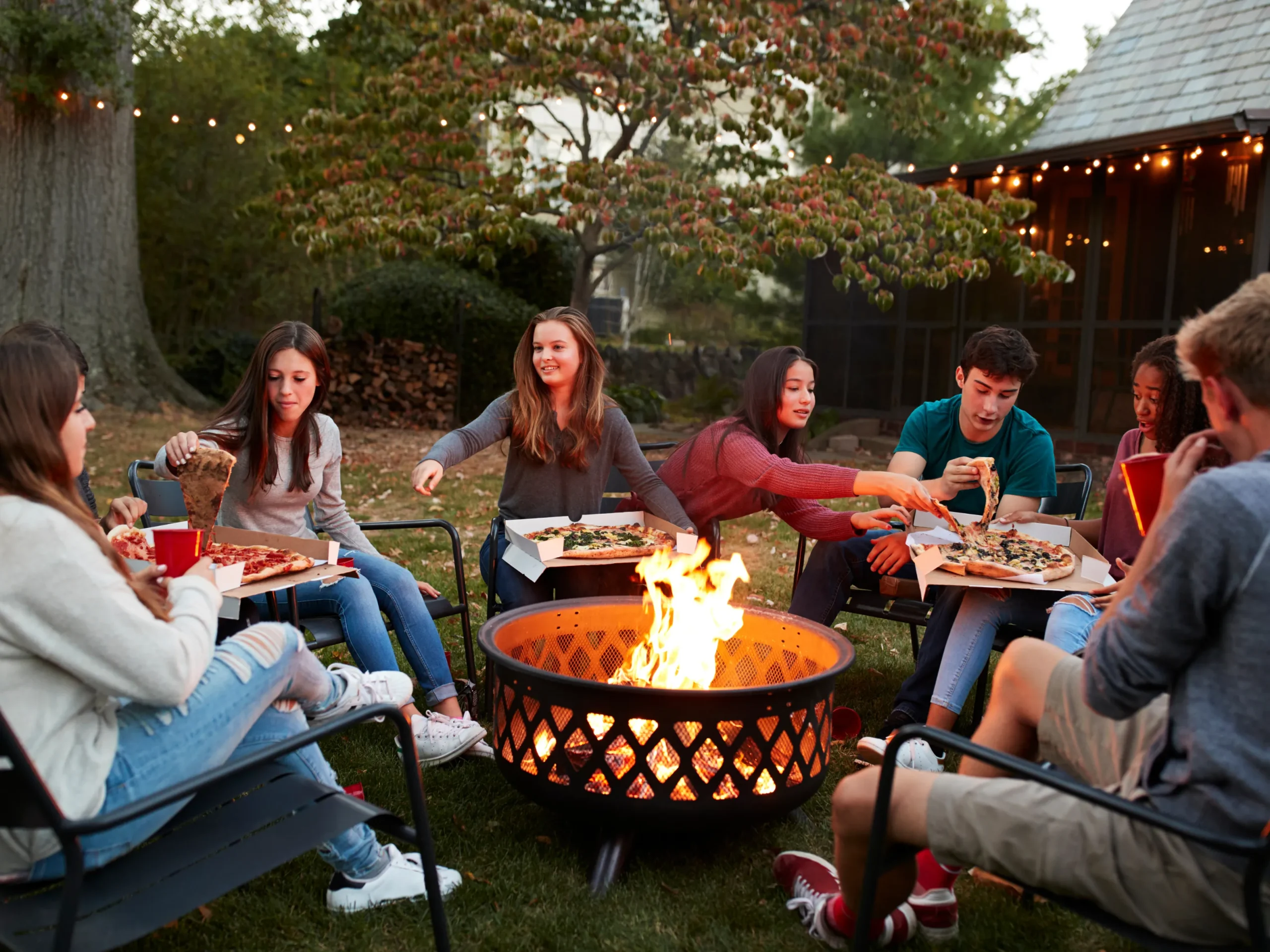 friends enjoying snacks and sitting around a bonfire