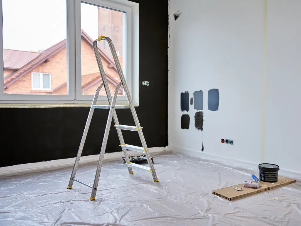 painting a room inside a home with black paint